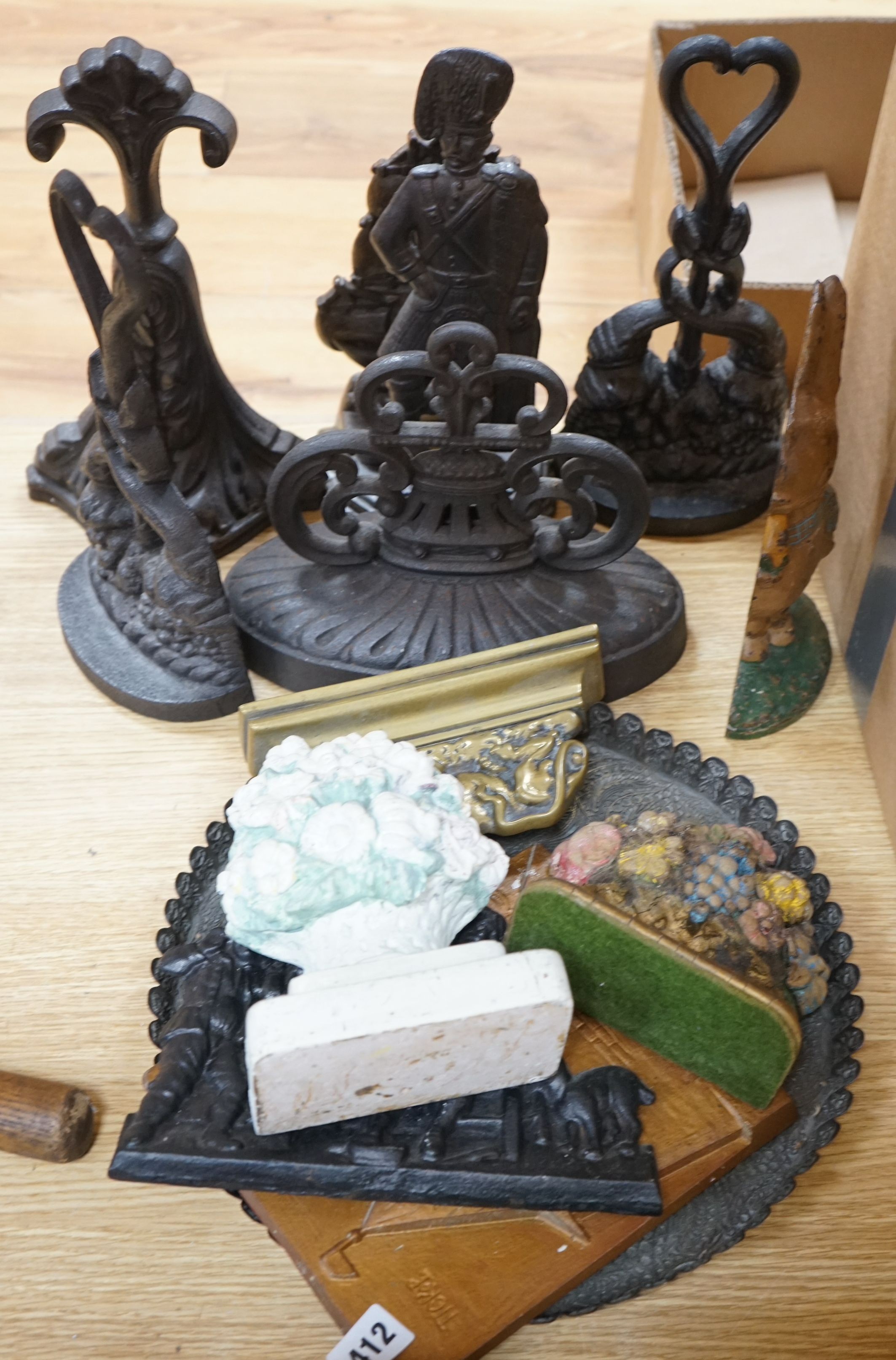 Eight cast iron door stops, a brass lion, a tray, two panels and two floral plaster models, (13)